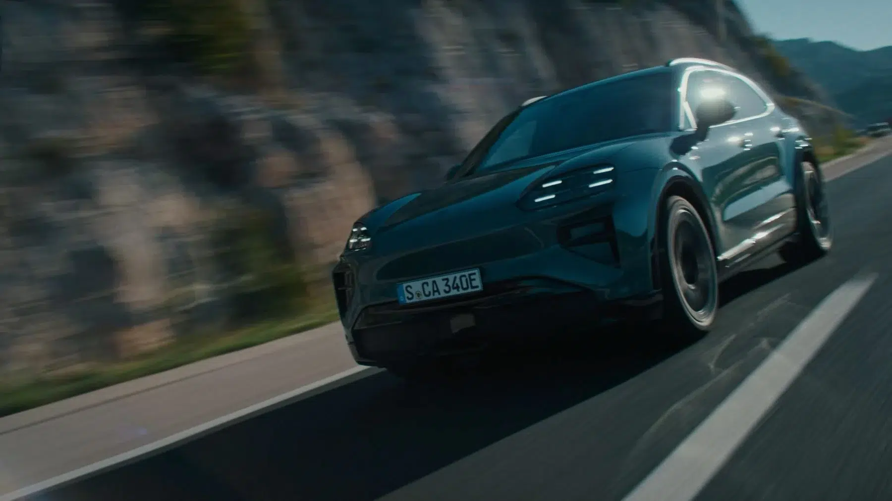 Porsche Cayenne Turbo Electric vert, vue avant trois quarts en mouvement