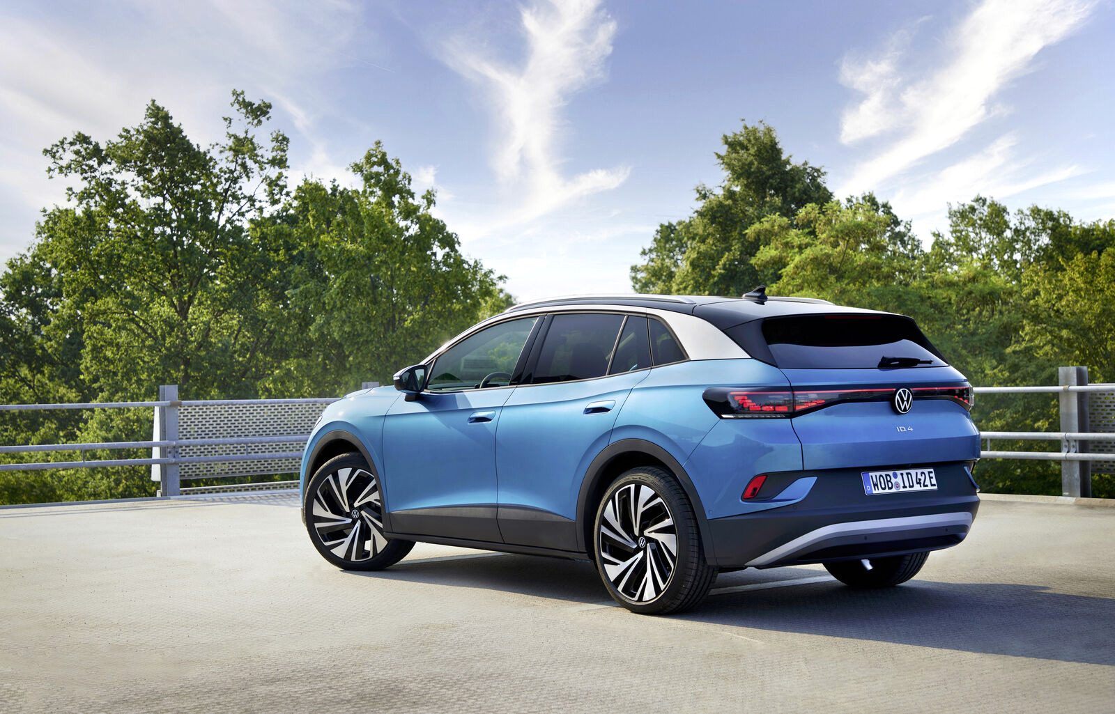 Illustration de sept voitures électriques alignées devant un podium vide
